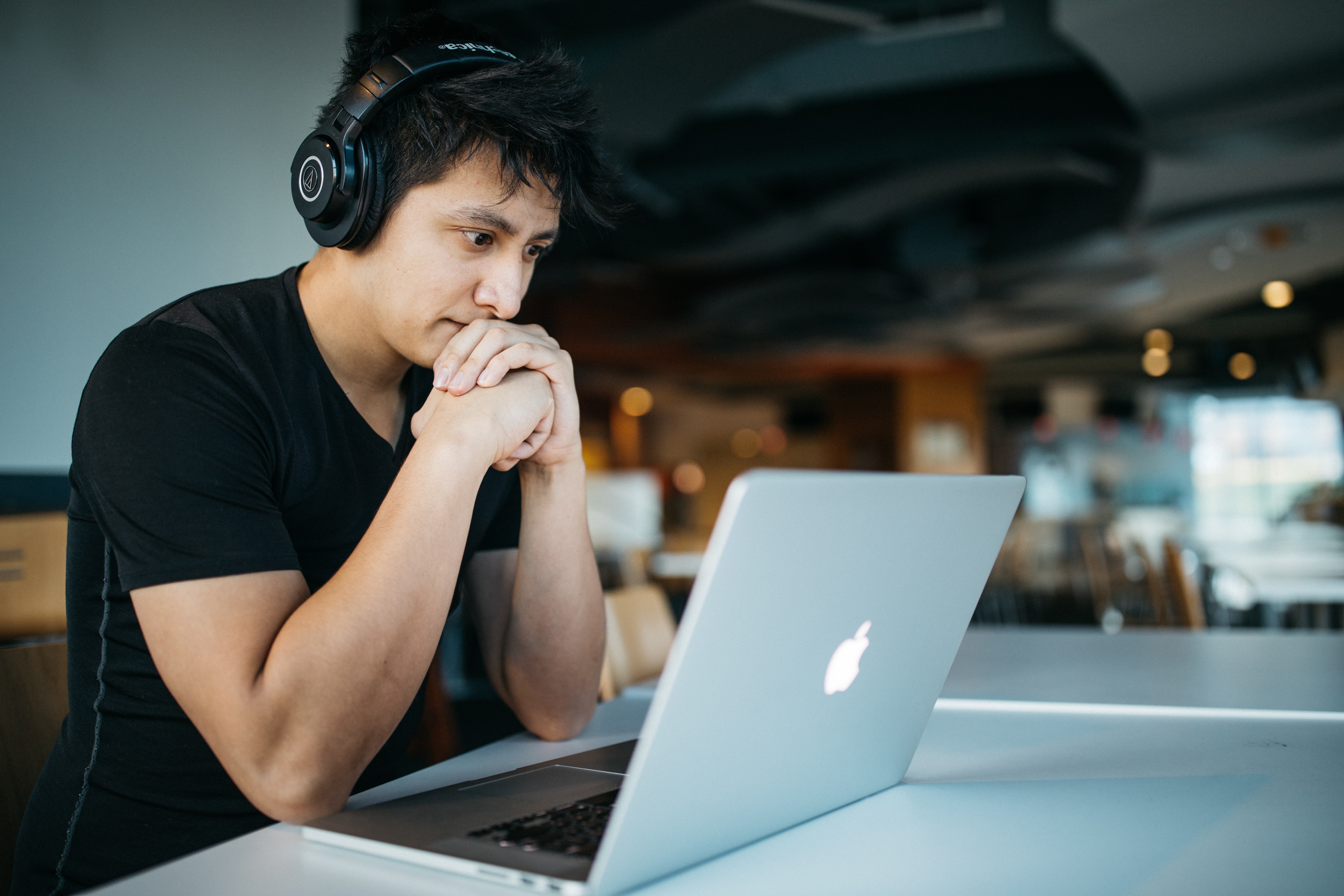Man with headphones on looking at a laptop