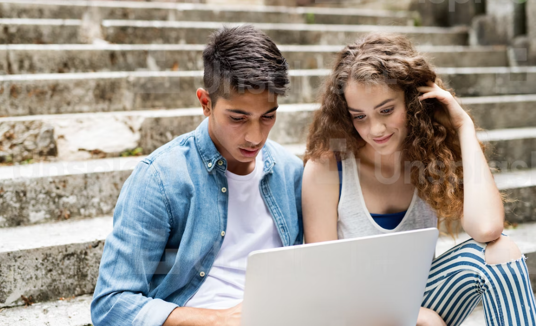 Two young people looking at a laptop