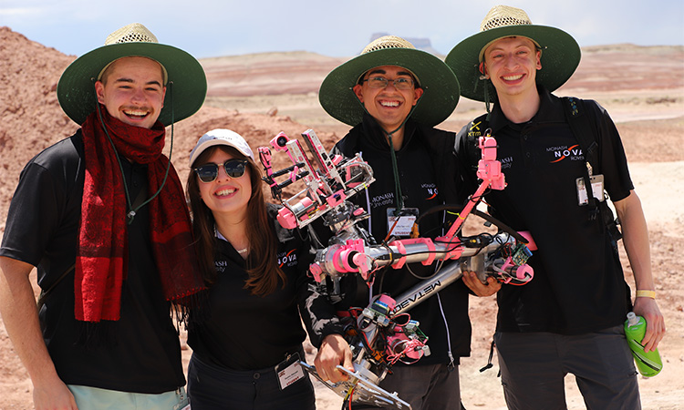 Image of four young people holding a pink space rover
