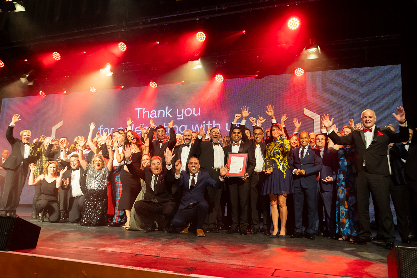 Excellence Awards winners 2023 on stage with arms in the air